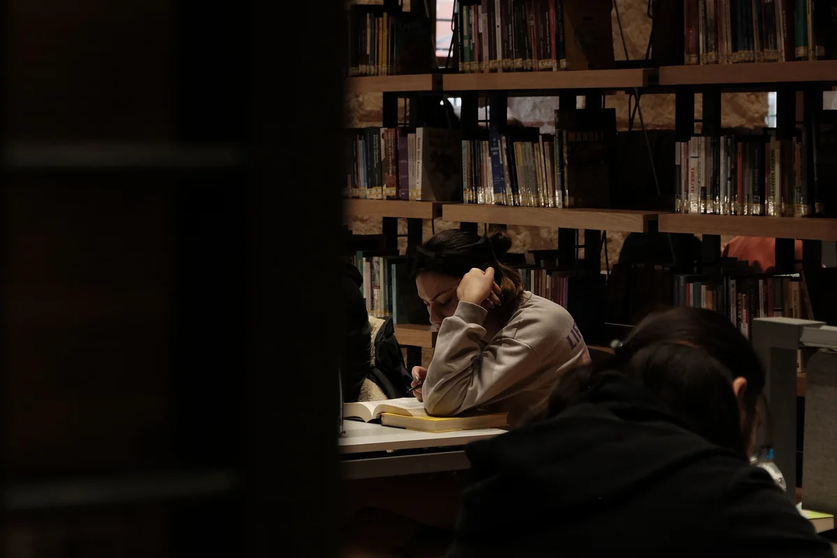 Mennesker læser og arbejder ved borde i et bibliotek