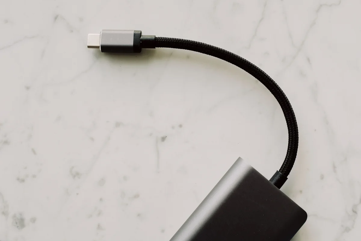 USB-C-stik og sort kabel på en lys marmorflade